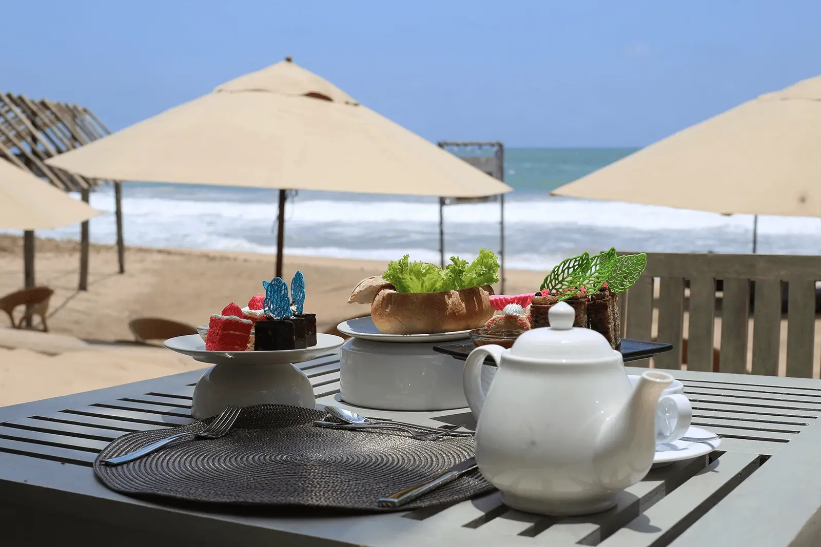 Breakfast with pot of tea served at a table on the private beach