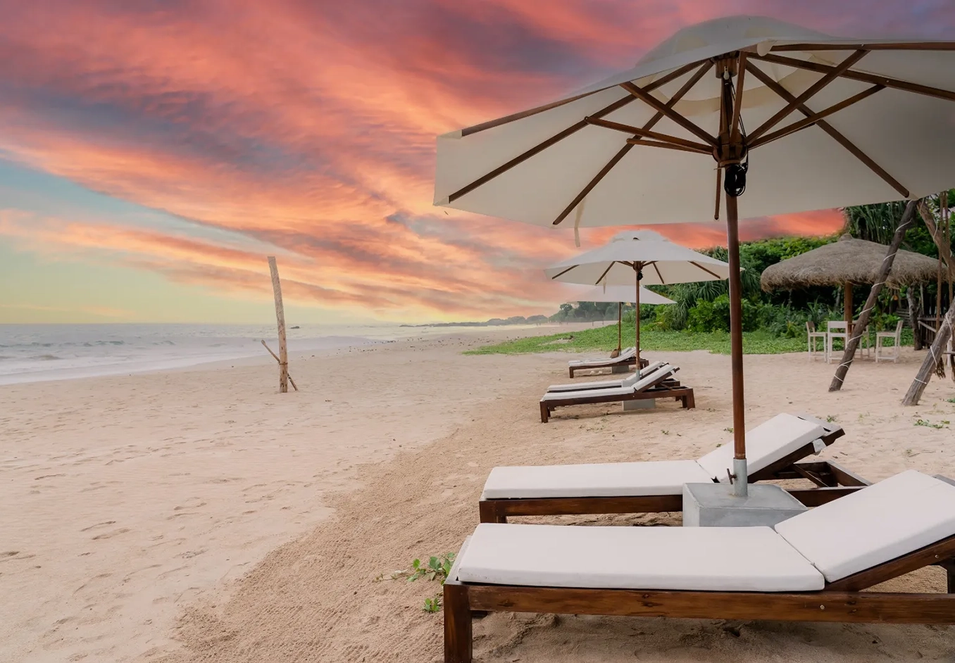Sunbeds aligned on the private beach on a golden sunset